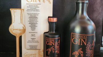 Ein elegantes Set aus Gin-Flaschen und einem stylischen Display. Die Verpackung betont die Qualität und das Design des Produkts.