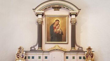 Ein schöner Altar mit einem Gemälde der Jungfrau Maria und einem Kind. Die goldenen Verzierungen verleihen dem Kunstwerk eine besondere Eleganz.