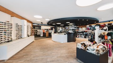 Ein moderner Laden mit einer großen Auswahl an Sonnenbrillen und Accessoires. Die helle, einladende Gestaltung schafft eine angenehme Einkaufsatmosphäre.